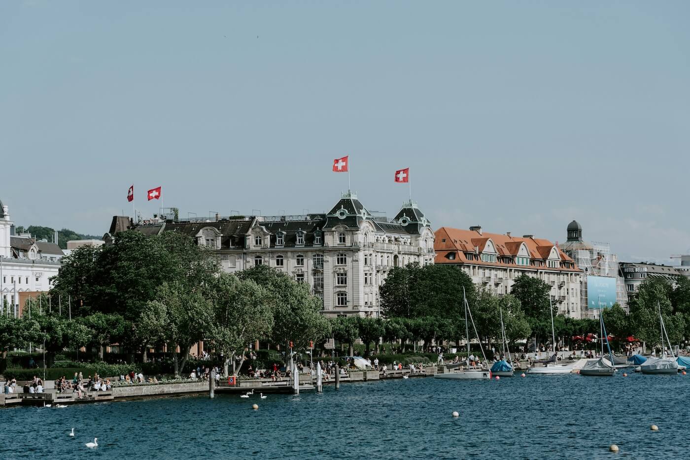 Building in front of water with Swiss flags on it