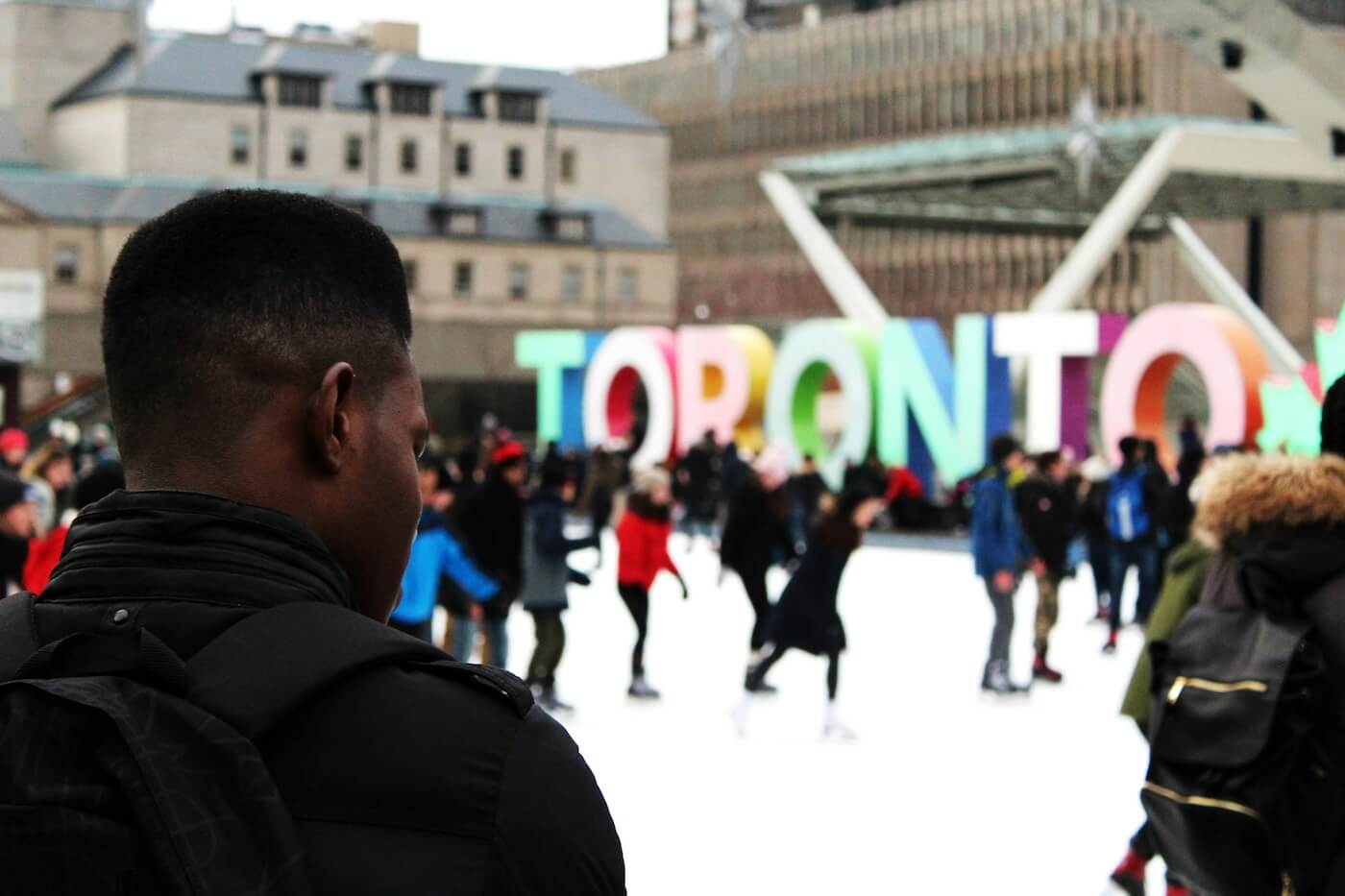 Ice skaters in front of Toronto sign