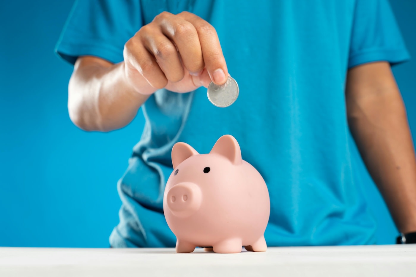 Person putting money in a piggy bank
