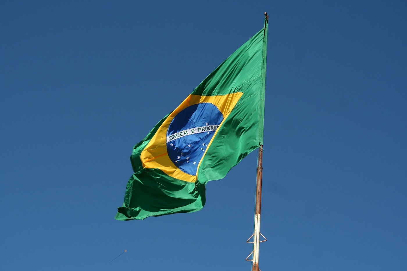 Brazilian flag waving against a blue sky