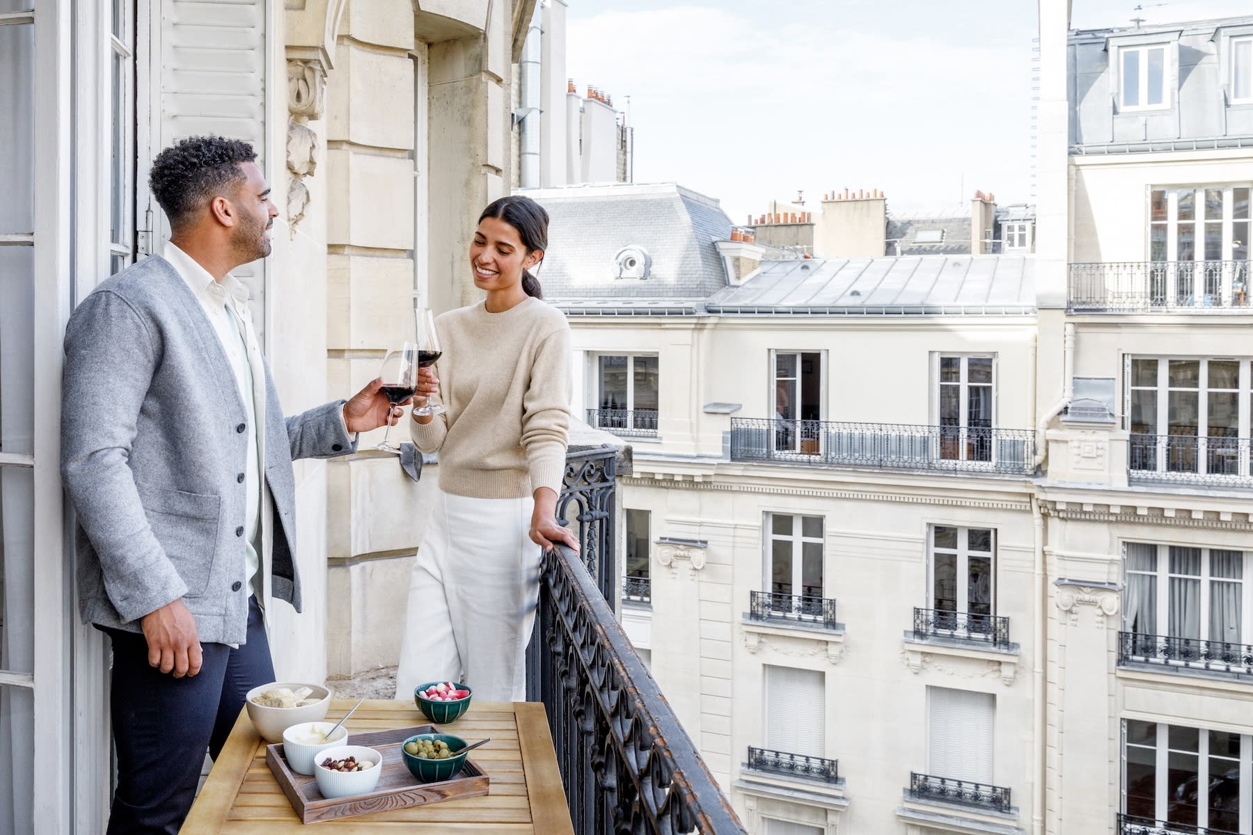 couple having wine on balcony is Paris