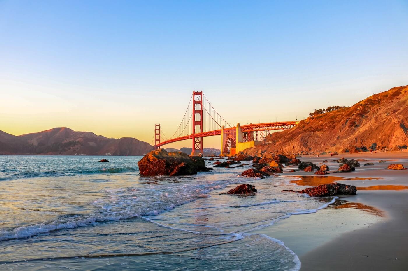 sunrise in san francisco with an ocean view and the golden gate bridge in the background