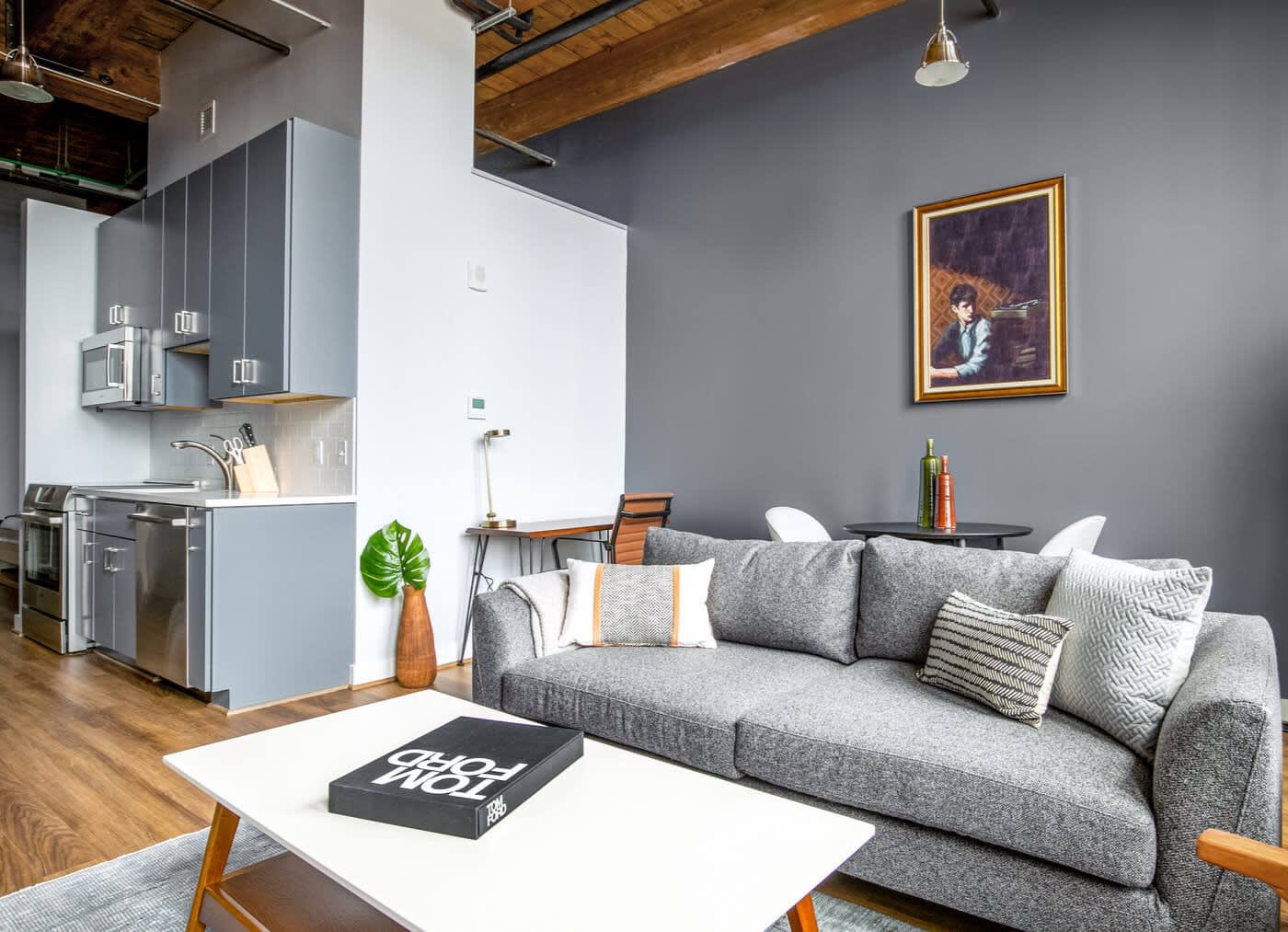 blueground apartment open-plan kitchen, couch and walls in grey tones with a white woody coffee table