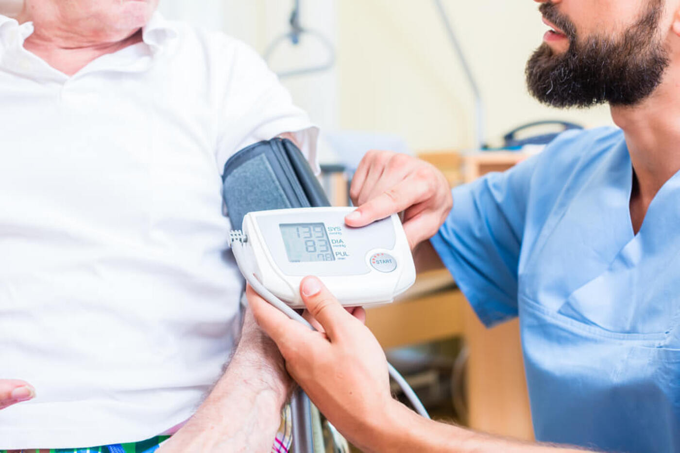 male nurse taking patient's blood pressure reading