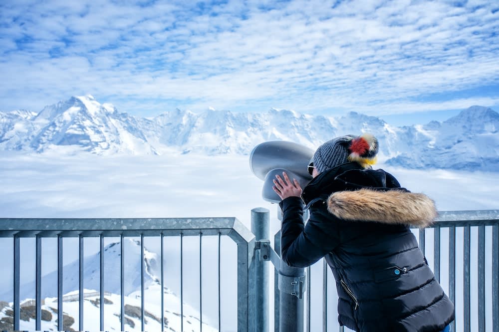 person looking at snowy mountains