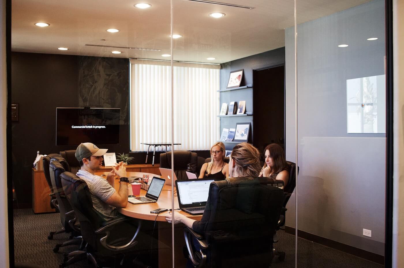 workers sit in a meeting discussing a project