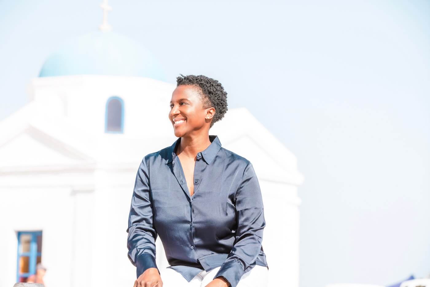 a smiling woman poses in front of a church