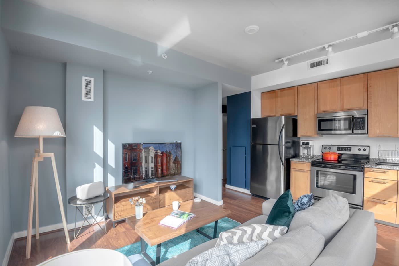 living room kitchenette with detailed blue rug and wooden coffee table