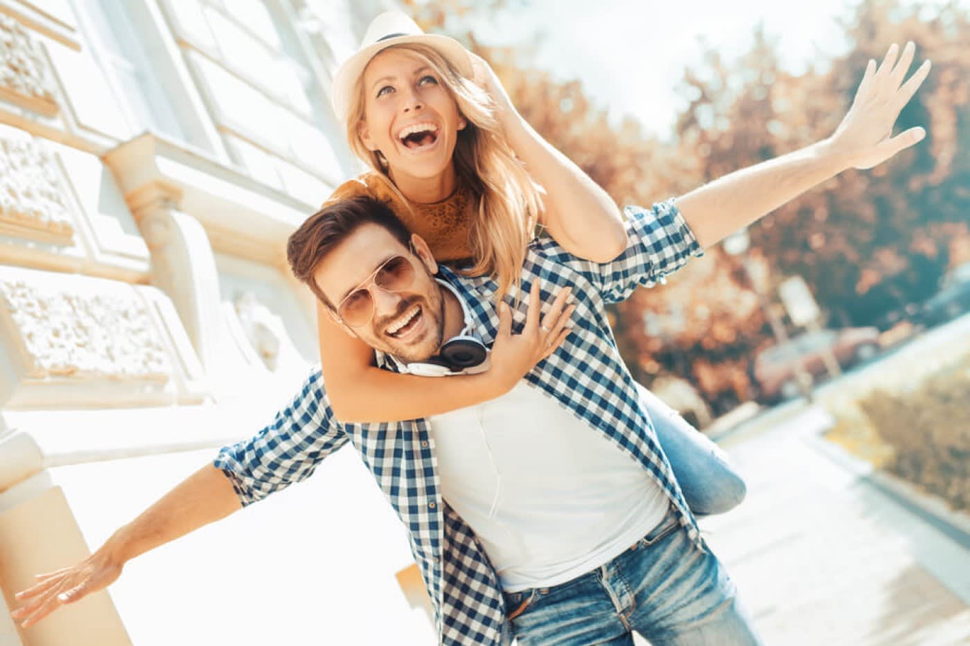 woman rides on mans back while he gives her a piggy back ride out in the california sun