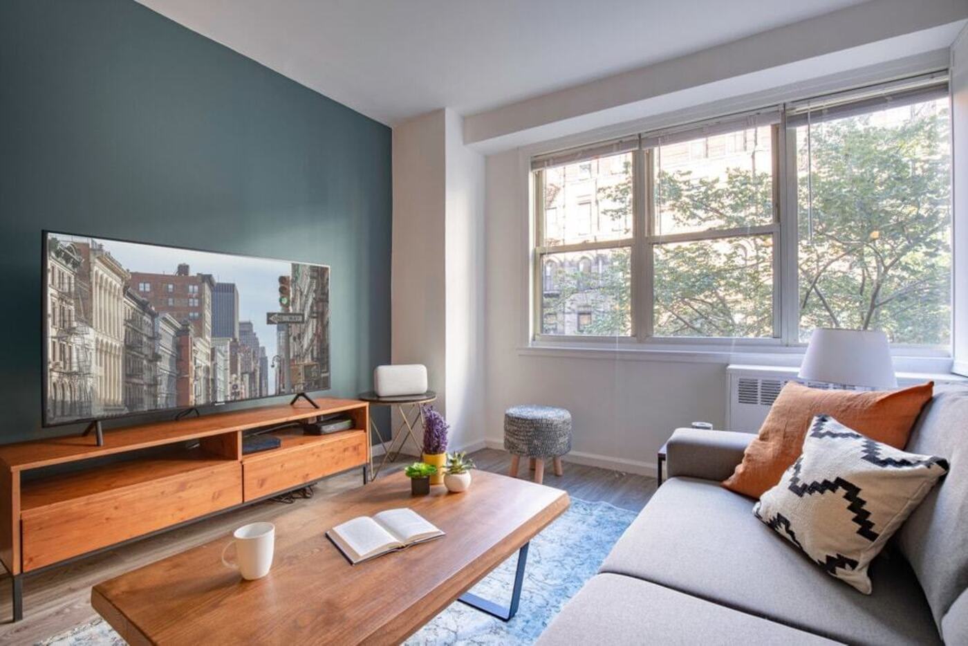 blueground Columbia Off Campus Housing Off Campus Housing NYU apartments near NYU upperlevel apartment living room with orange cushion on grey couch