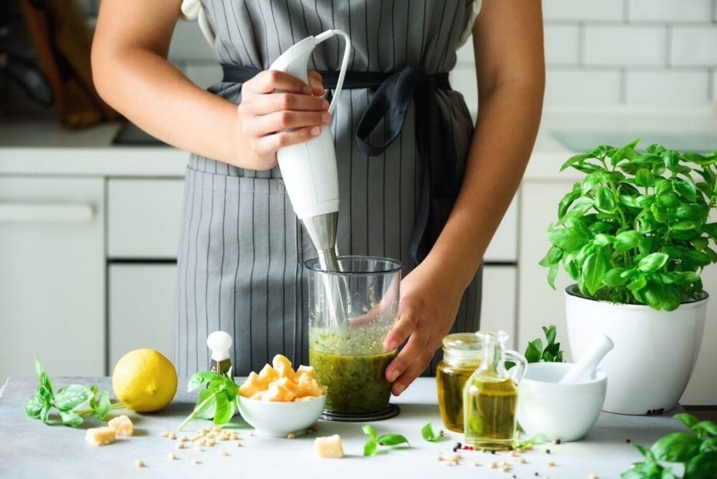 Home cook using a hand blender with fresh ingredients