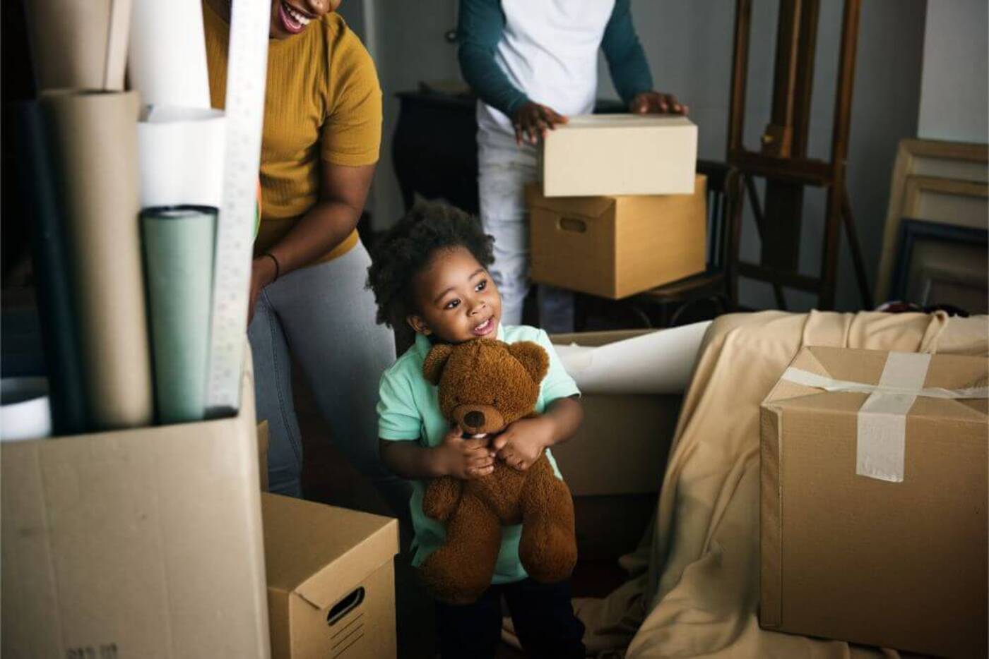 relocation management company a little boy holding a teddy bear amongst boxes