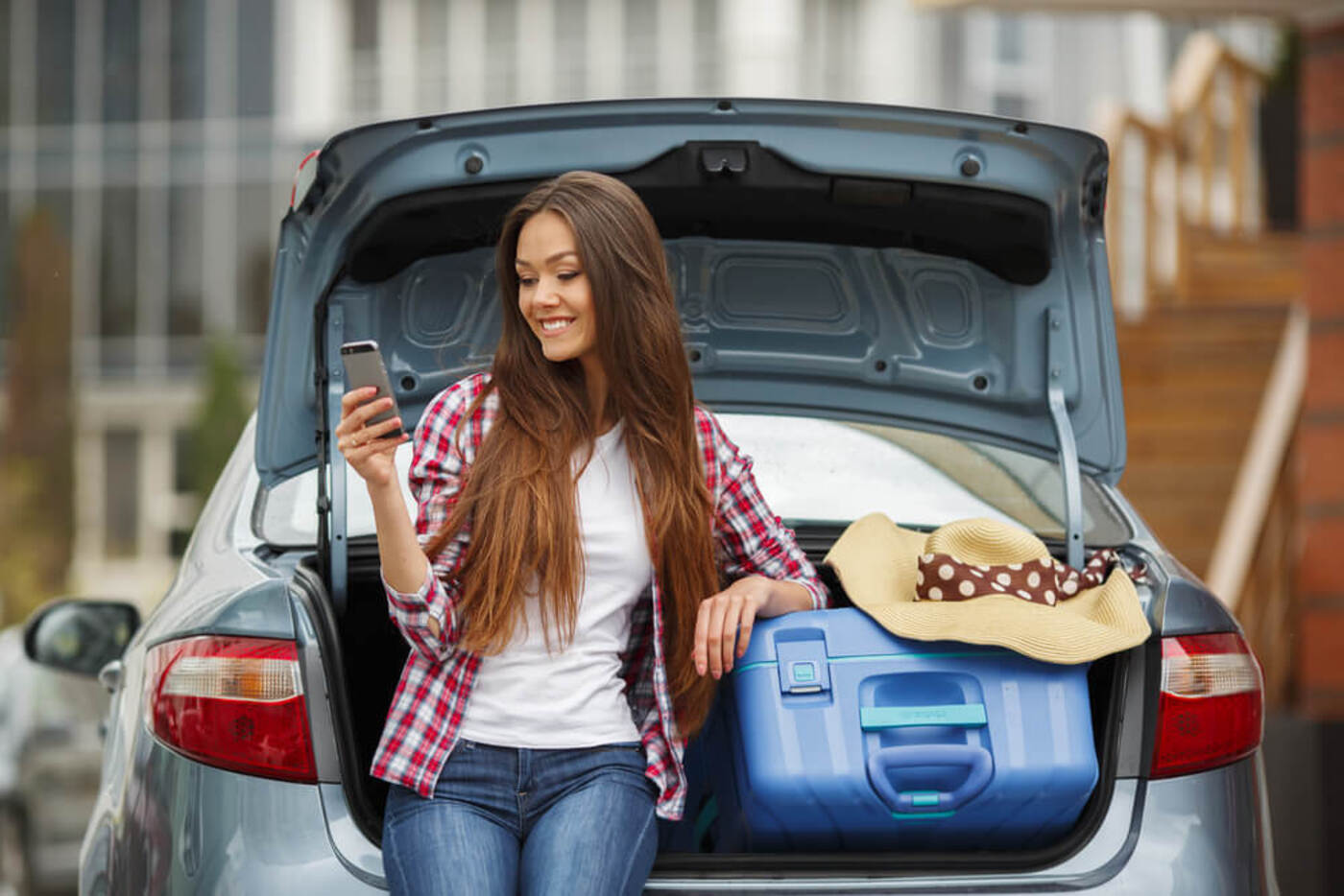 carshare in Chicago woman with the trunk of her car open and her cellphone in hand
