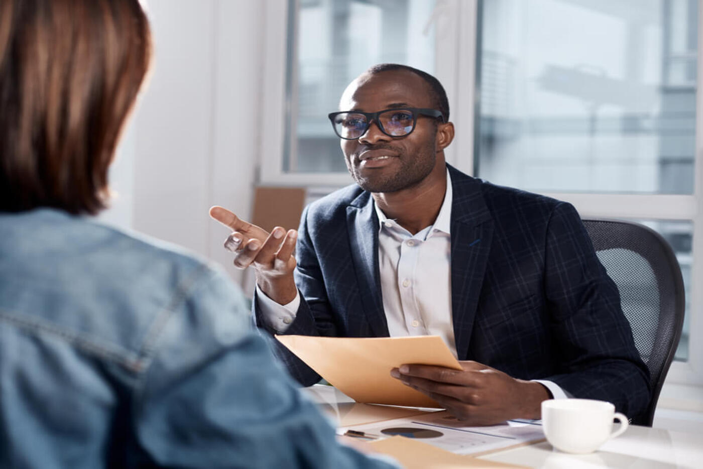 two people sitting at a table having a meeting and discussing cosigning