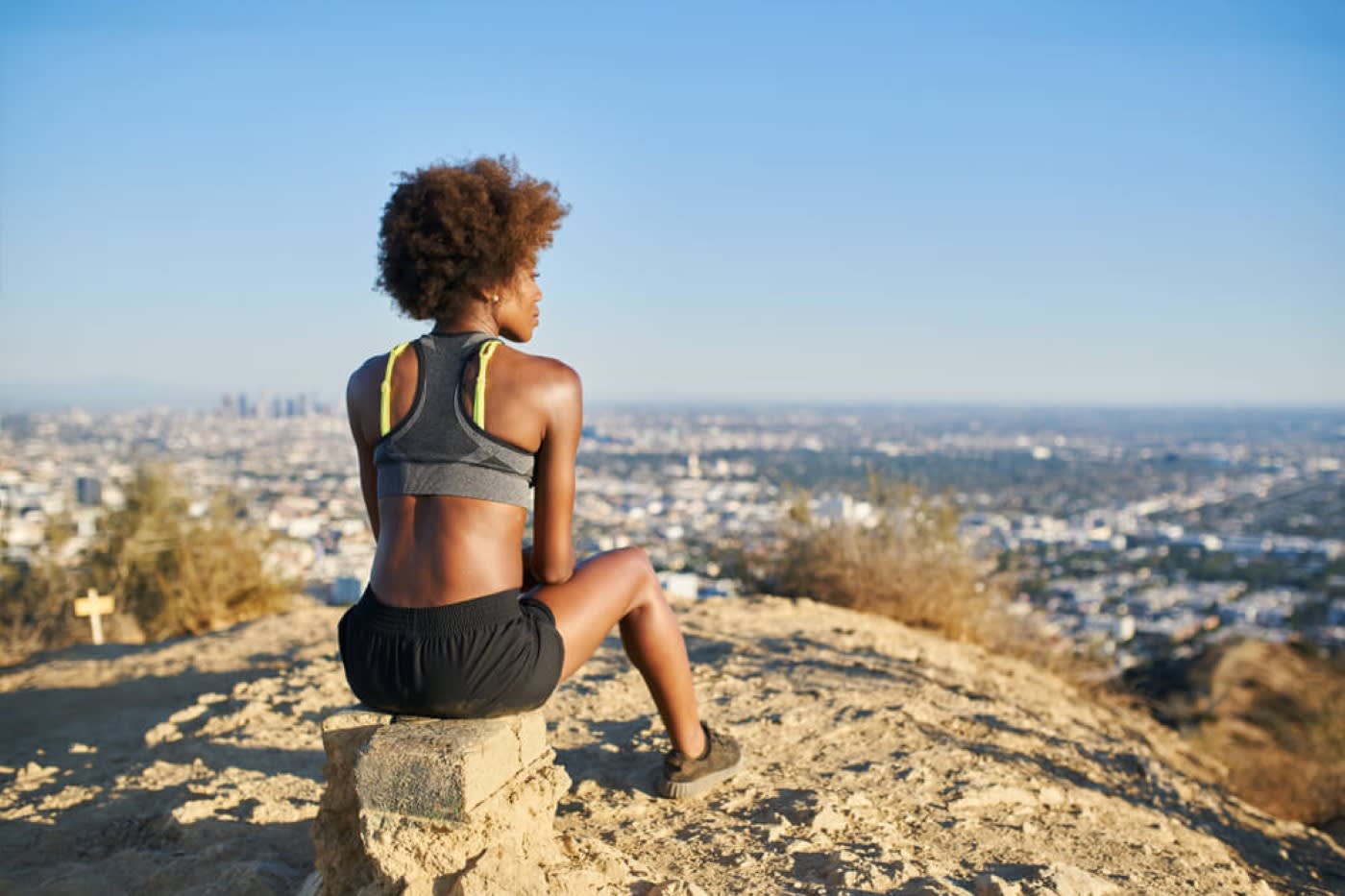 woman sits on a rock while hiking outdoors in los angeles