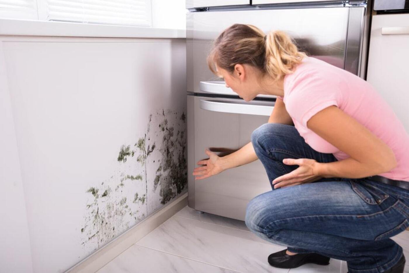 blueprint blueground how to test for mold woman in pink pointing at moldy wall