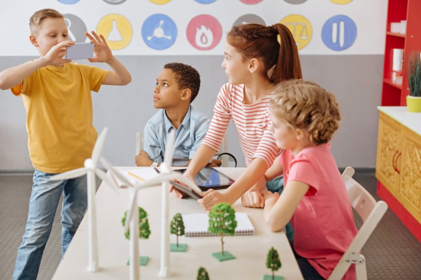 children school group looking at boy leader with yellow shirt