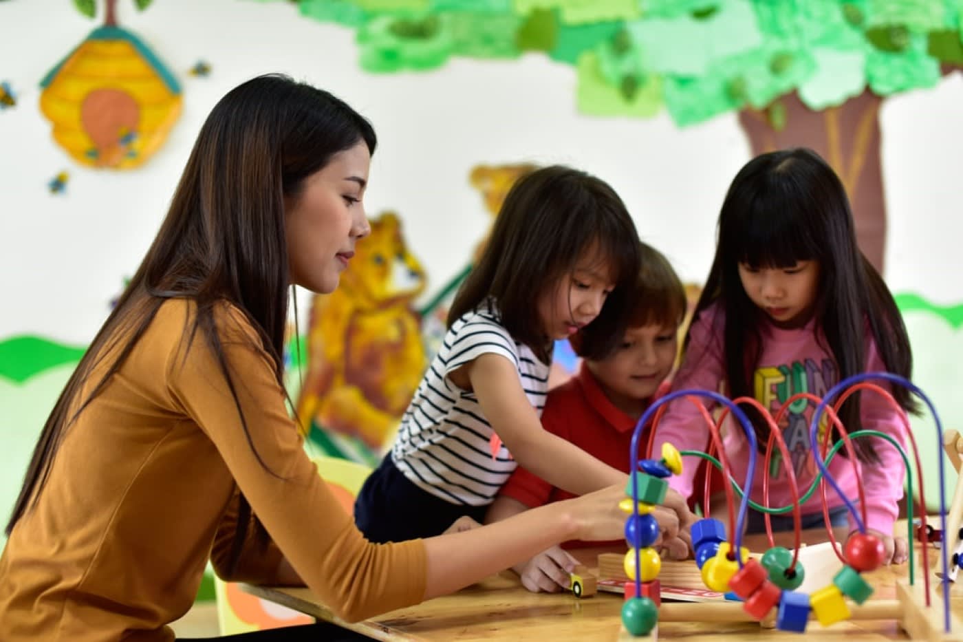 teacher and children having fun learning using toy