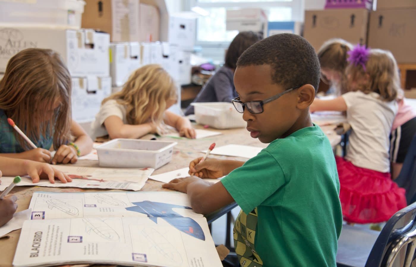 Elementary school children drawing in class.