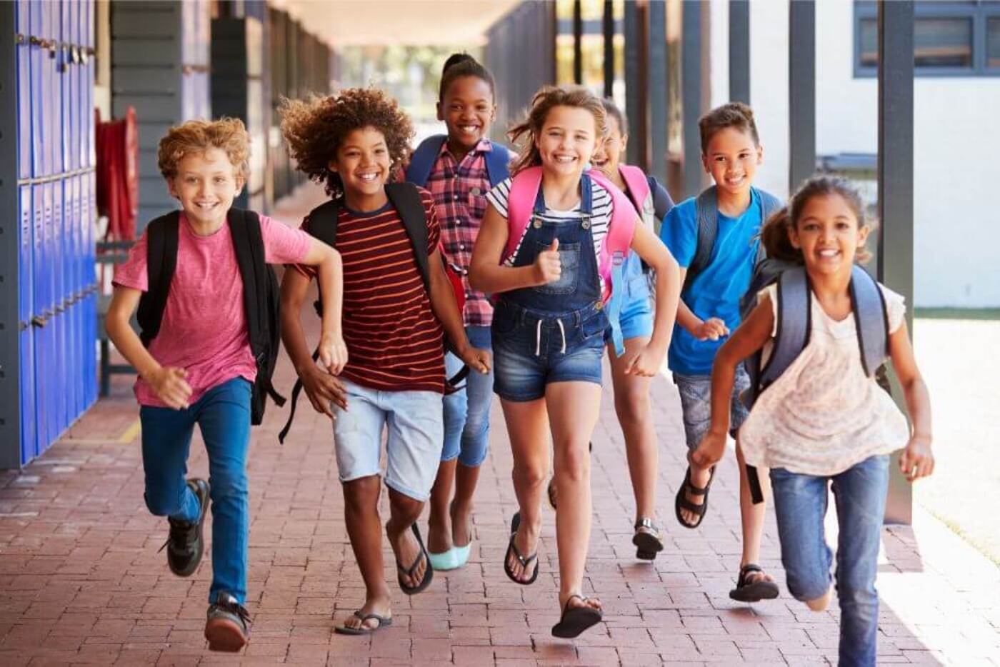 Group of school kids running in a school corridor