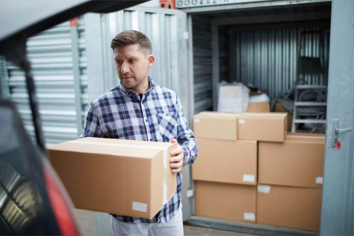 man moving boxes into a storage unit
