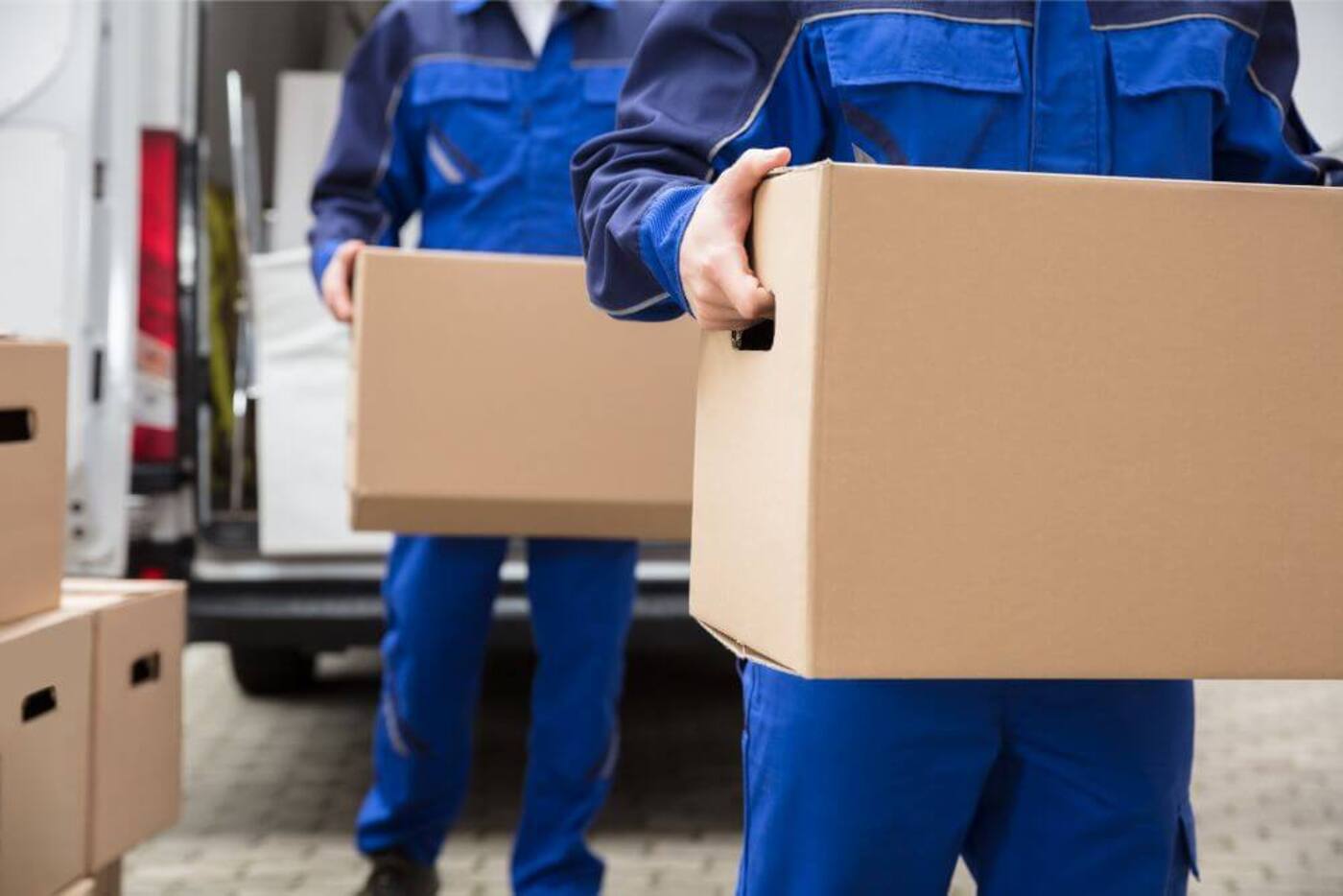 Two men from relocation company carrying boxes