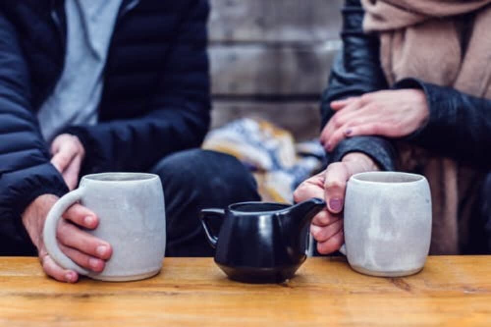 seattle apps man and woman holding tea cups that are sitting on a table