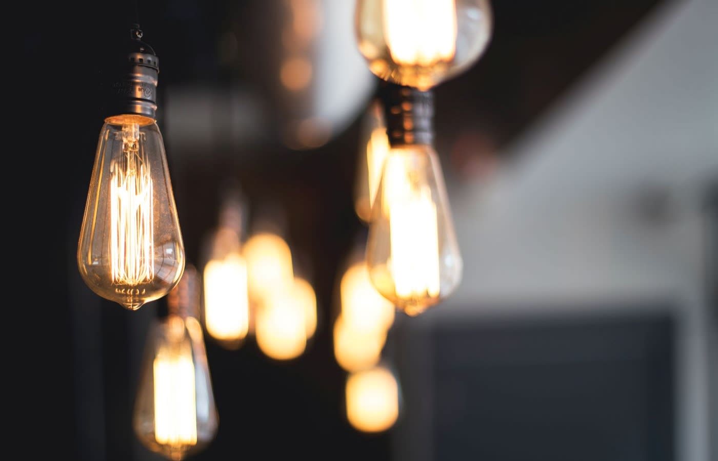 A row of filament lightbulbs hanging from a rooms ceiling.