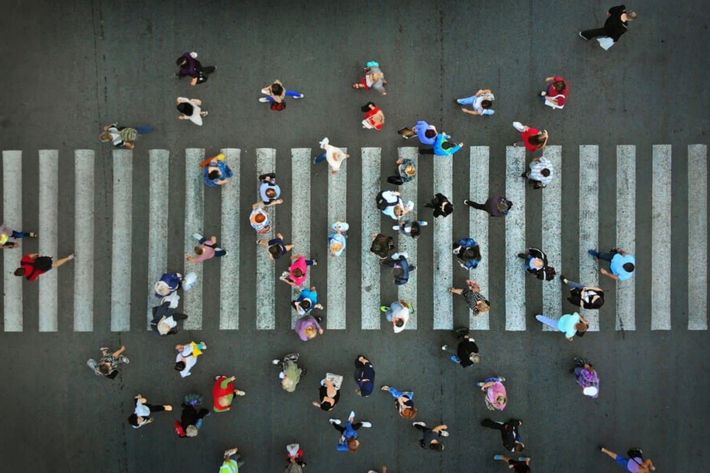 birds eye view look at a crosswalk full of pedestrians crossing the road