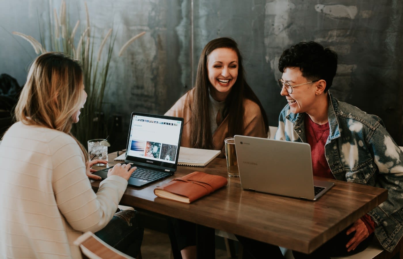 a group of people chatting while working on their laptops