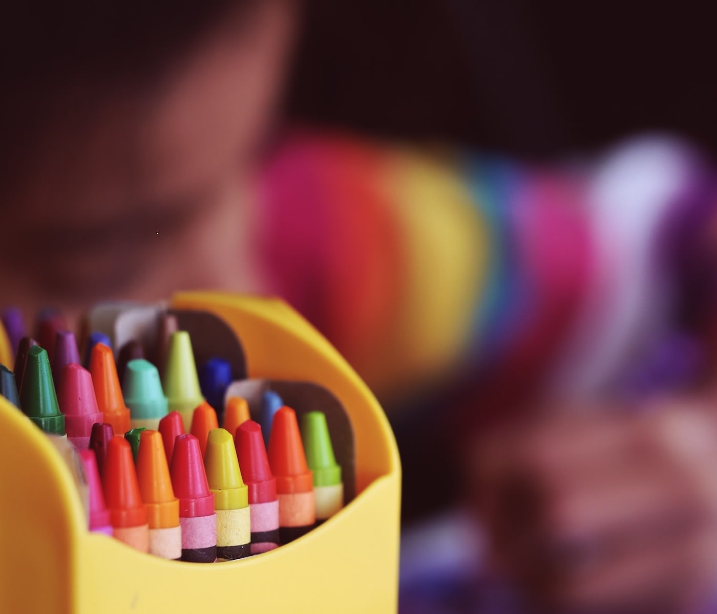 crayon case with a child drawing in the background