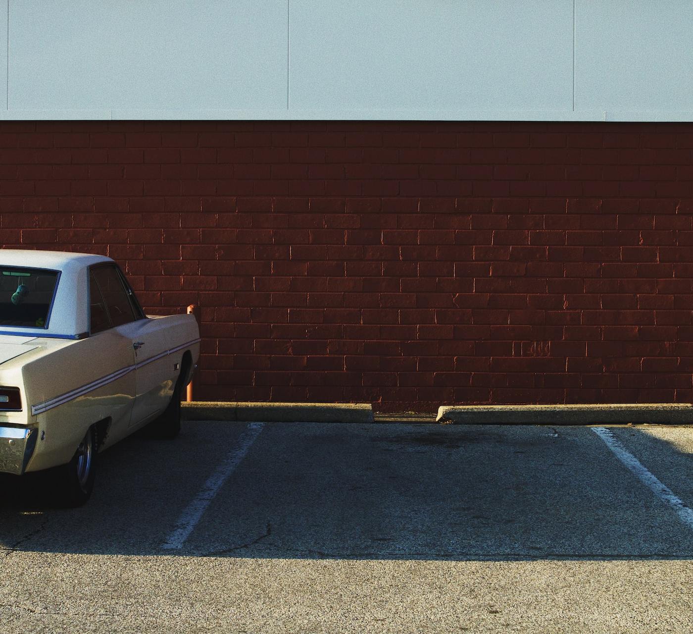 two parking spaces next to each other, one occupied one empty