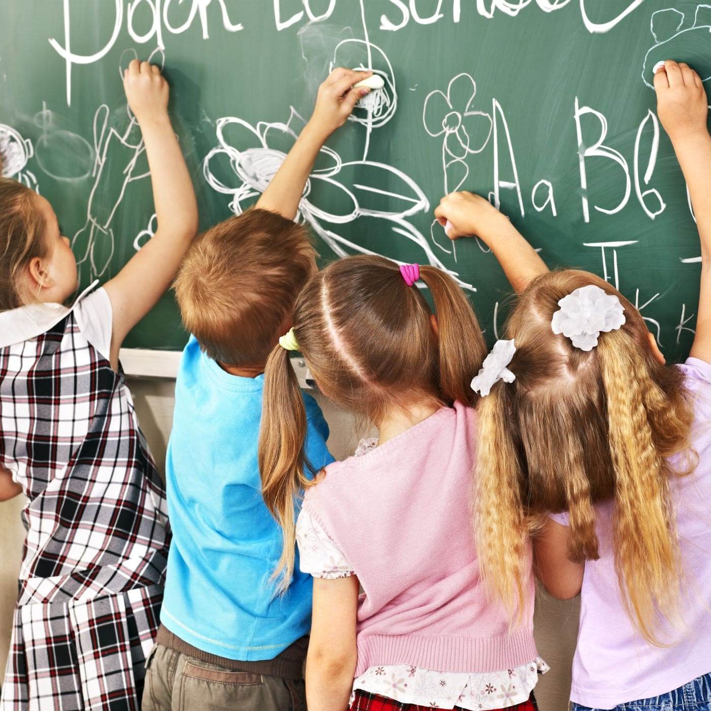 children writing on chalkboard at school