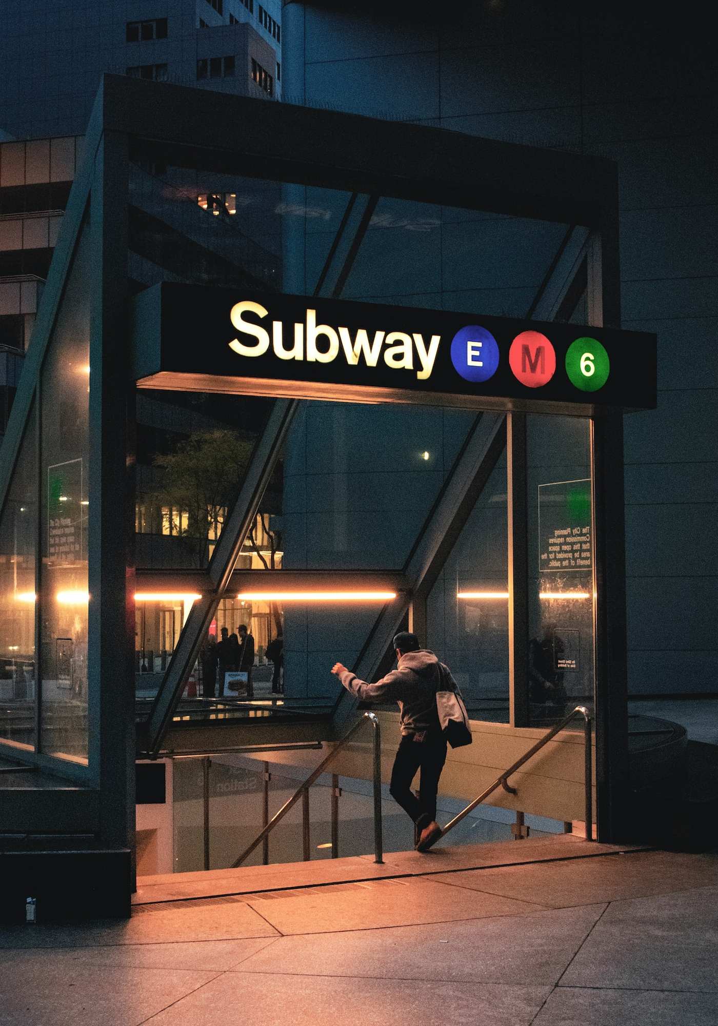 subway station entrance in Manhattan nyc, lit during nighttime