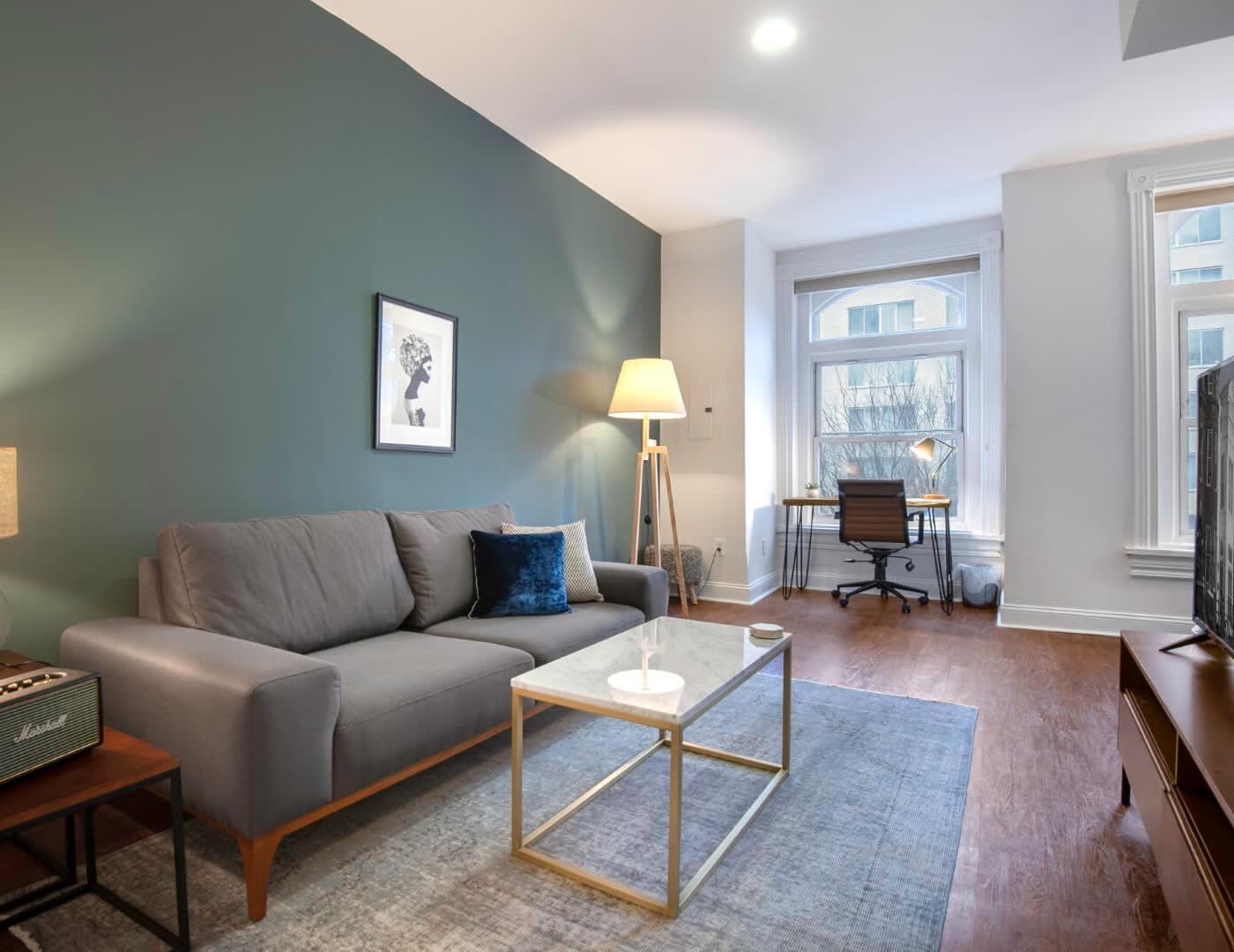 furnished apartment living room with a grey couch and a marble table