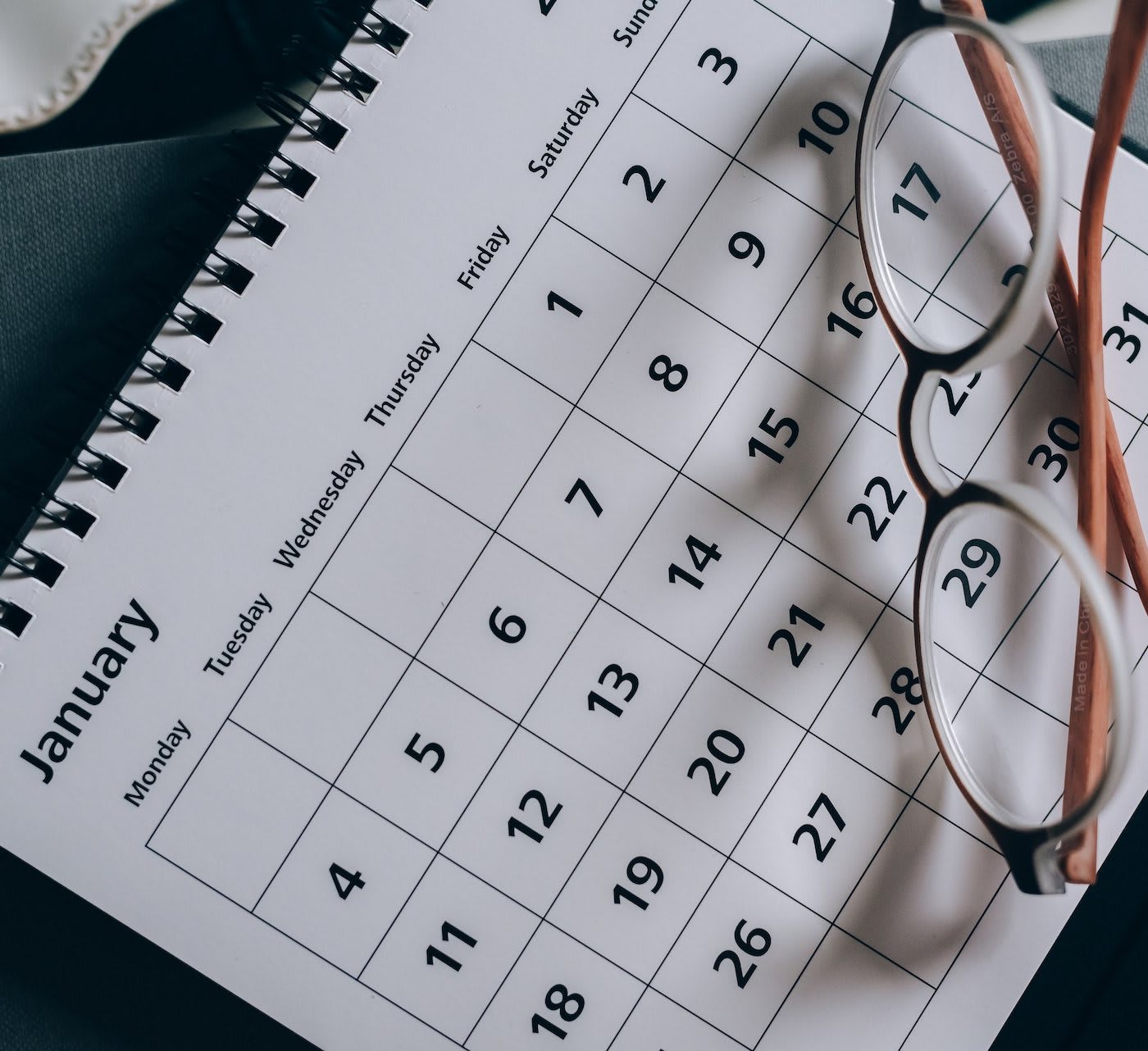 january calendar with a pair of glasses on top