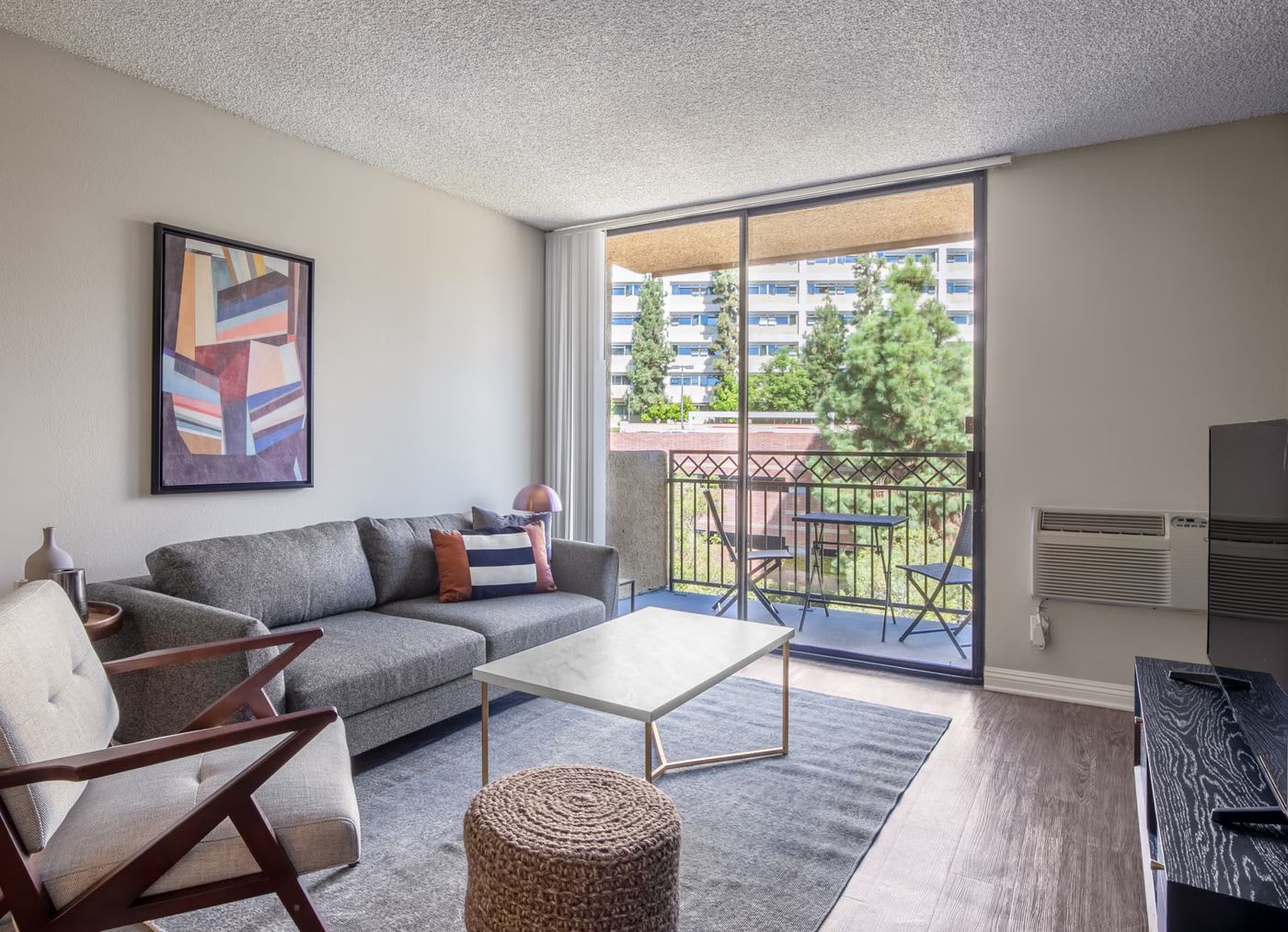 a quiet westwood living room with greenery outside the window