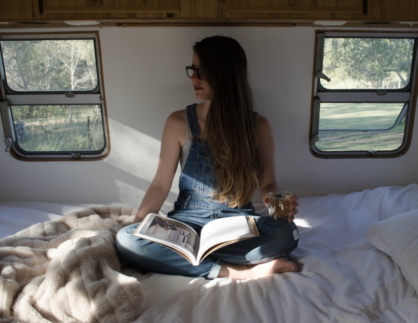 woman reading sitting on a bed in a RV