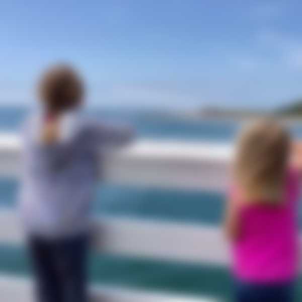 Two girls watch surfers in Malibu