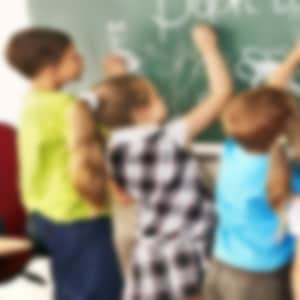 international schools Boston children writing on chalkboard at school