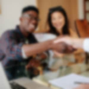 man shaking hands with realtor after closing deal on new home