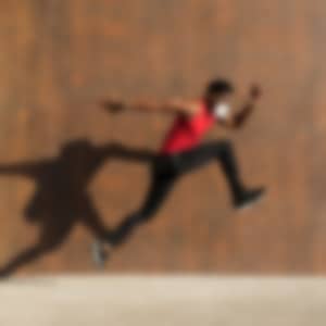 a man is jumping/running while wearing a protective mask