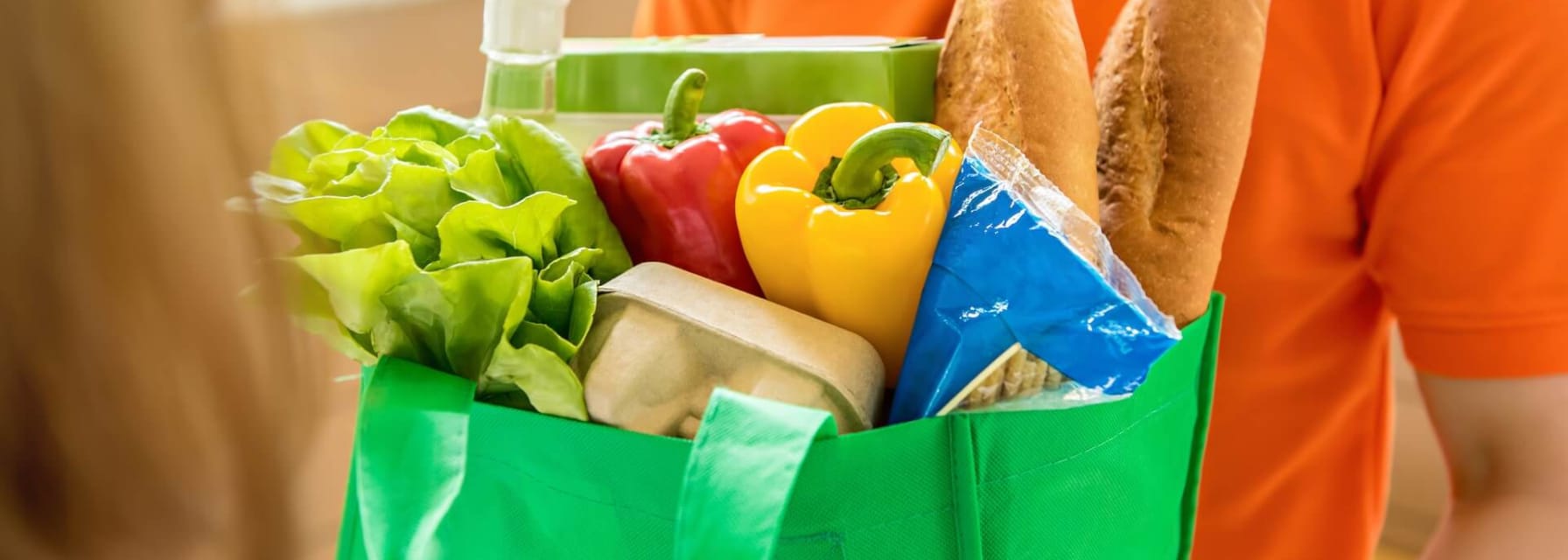 Person delivering groceries in a bag