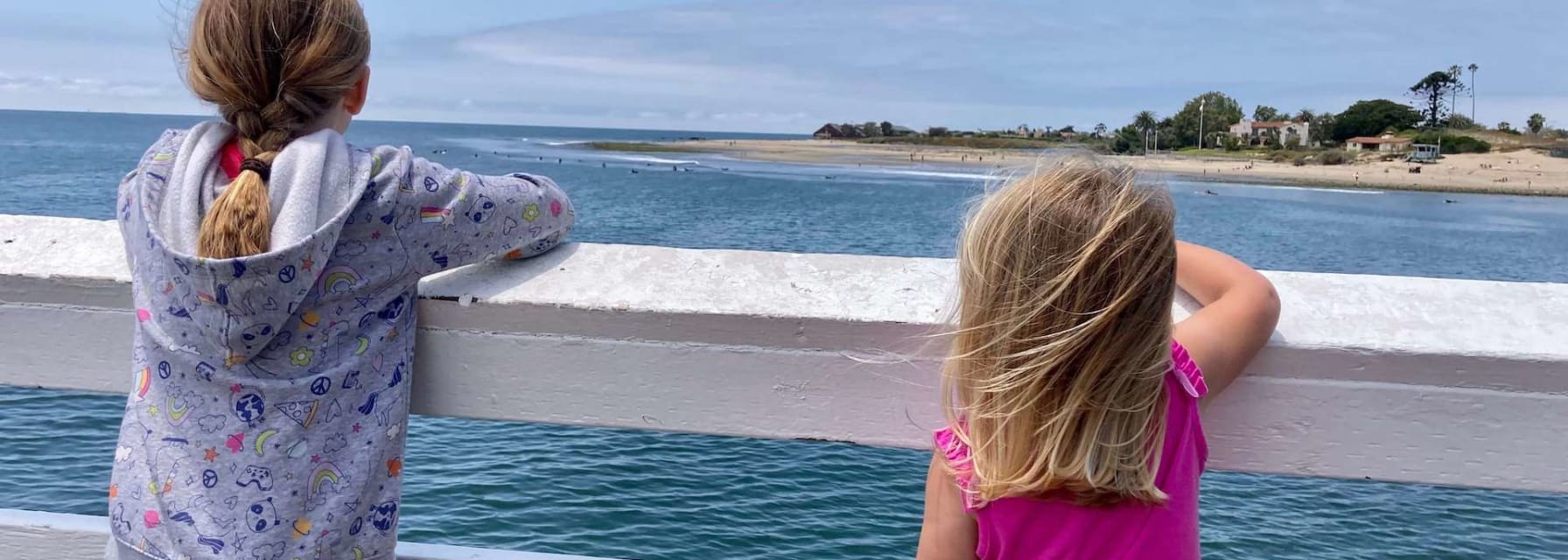 Two girls watch surfers in Malibu