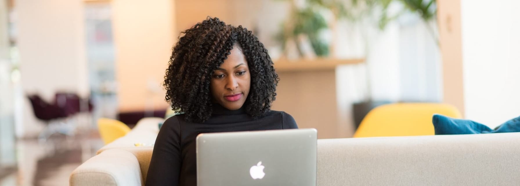 woman working on her laptop sitting on a couch