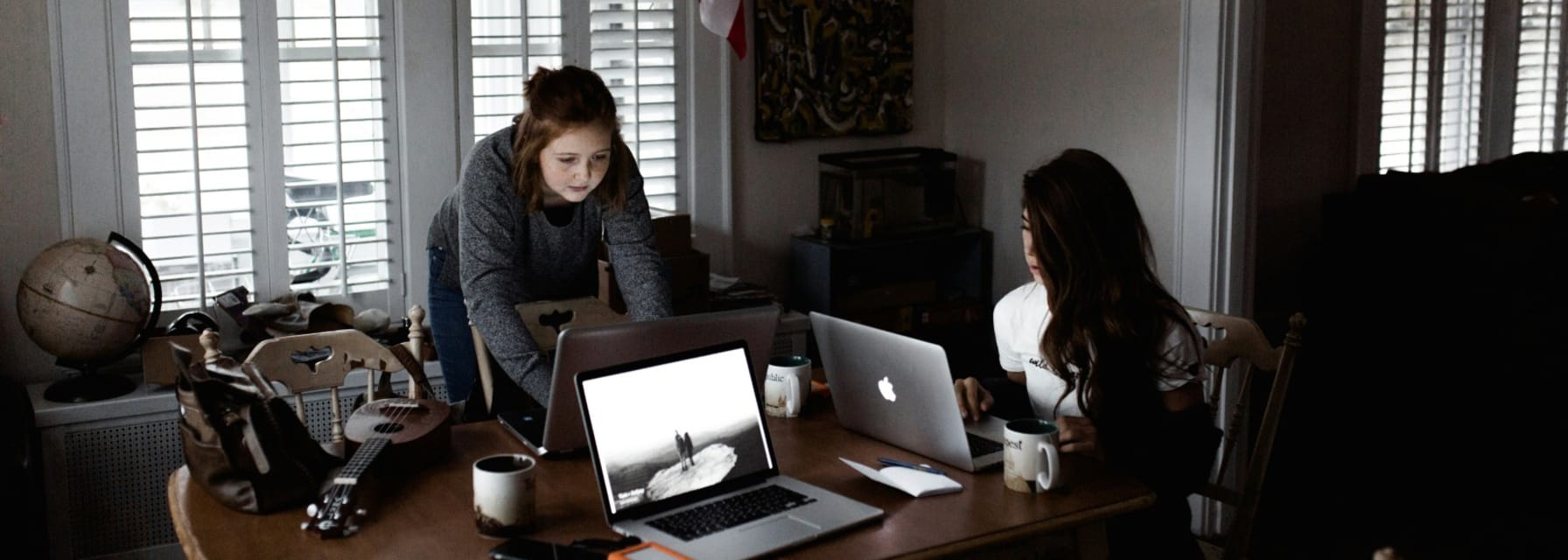 2 students working on their laptops in their student apartment