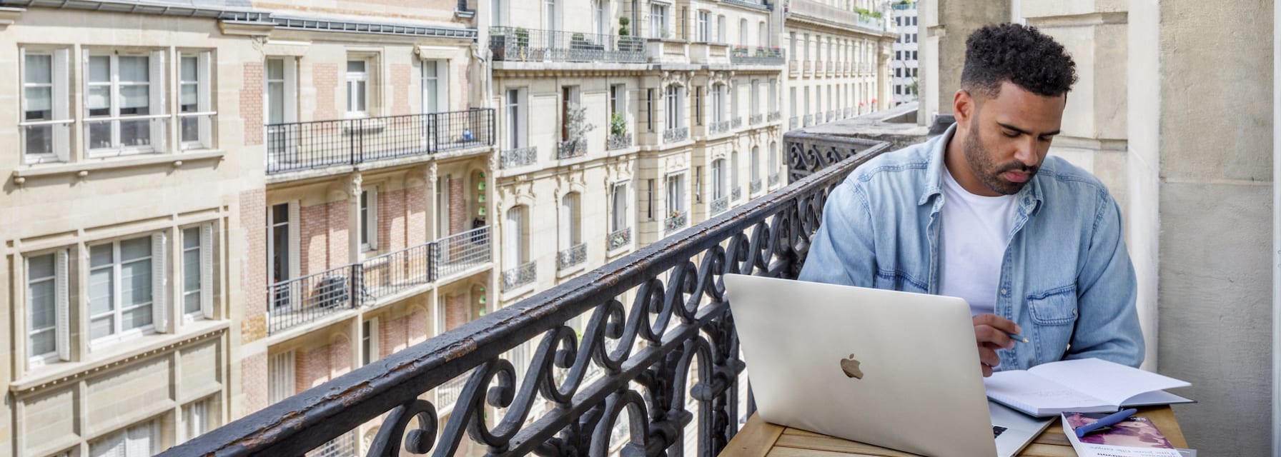 Man working on balcony at a Blueground apartment in Paris