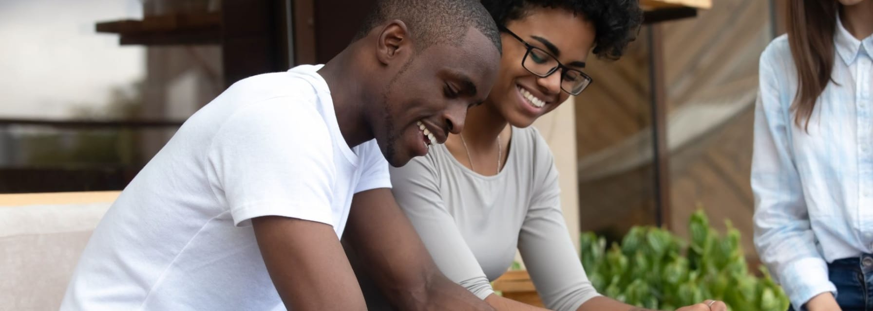 couple smiling while signing a lease agreement