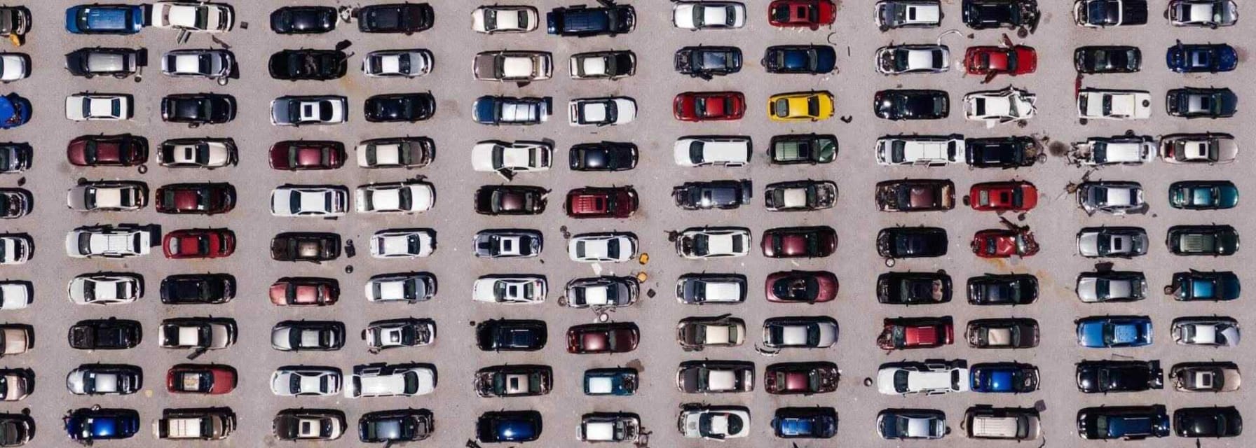 aerial shot of a car park filled with vehicles parallel parked in rows