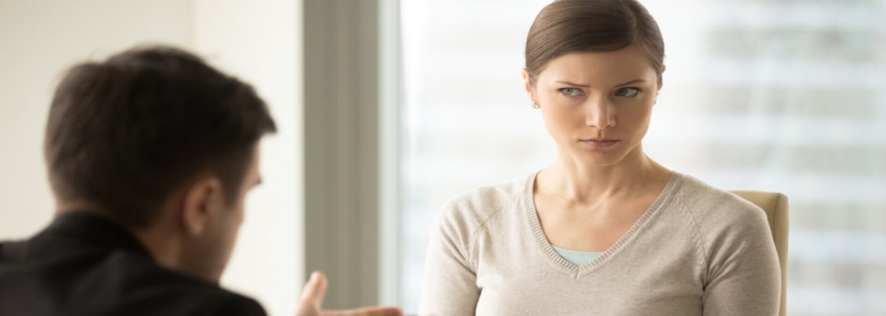 woman holding a paper staring at a man explaining a rental scam